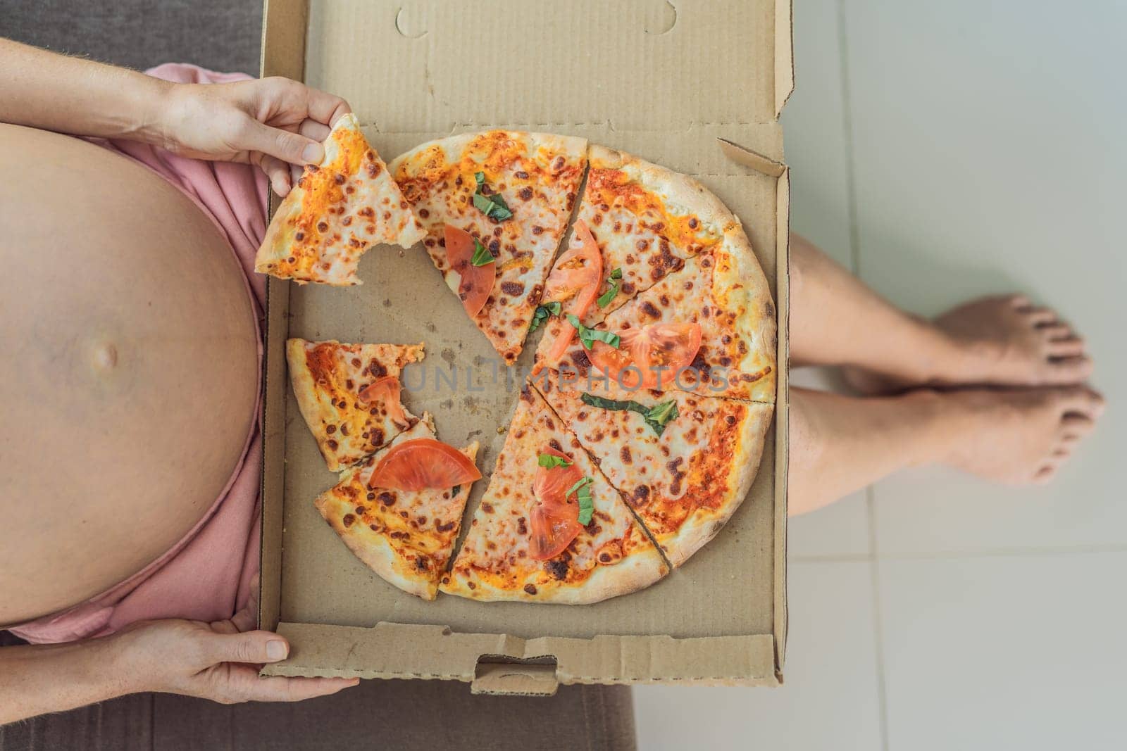 A pregnant woman enjoys a slice of pizza, savoring a moment of indulgence while satisfying her craving for a delightful, comforting treat. Excited Pregnant Young Lady Enjoying Pizza Holding Biting Tasty Slice Posing With Carton Box. Junk Food Lover Eating Italian Pizza. Unhealthy Nutrition Cheat Meal by galitskaya