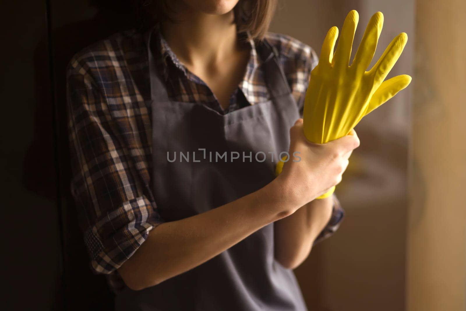 A woman in yellow rubber gloves does housework by africapink