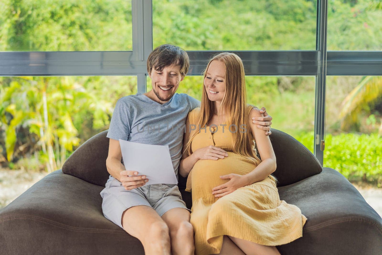 A joyful husband and his pregnant wife share a moment of excitement, smiling while looking at an important document, their faces radiating happiness and anticipation.