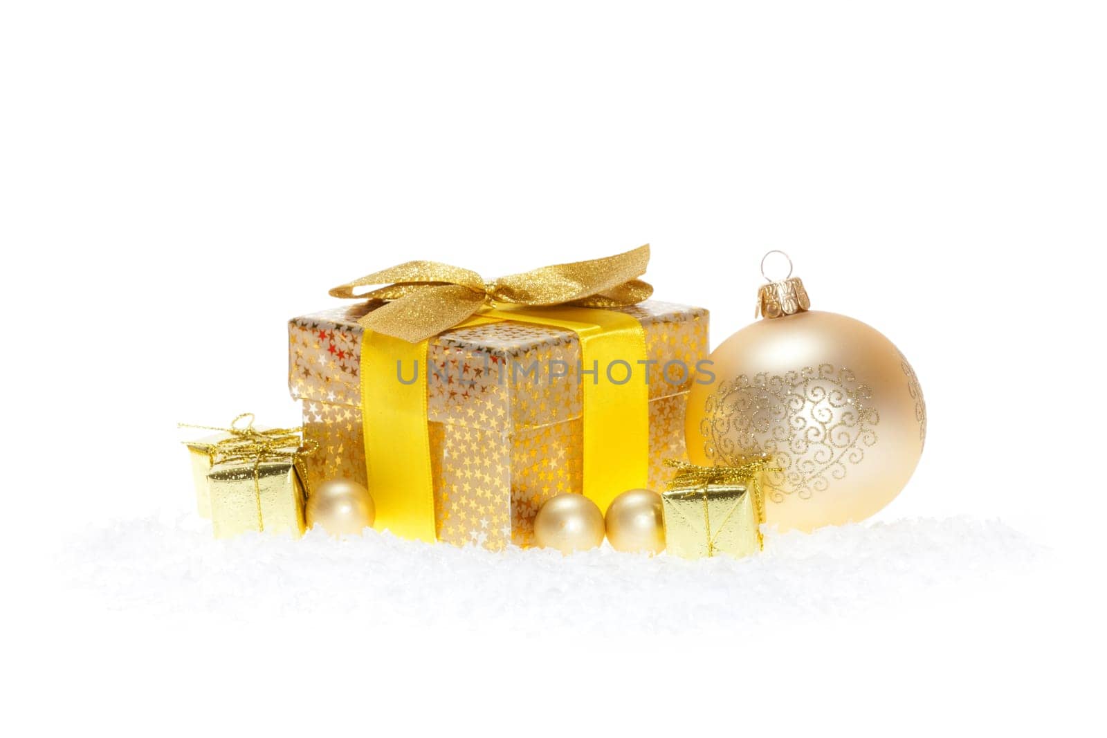 Package with bow,golden balls lying in the snow against white background