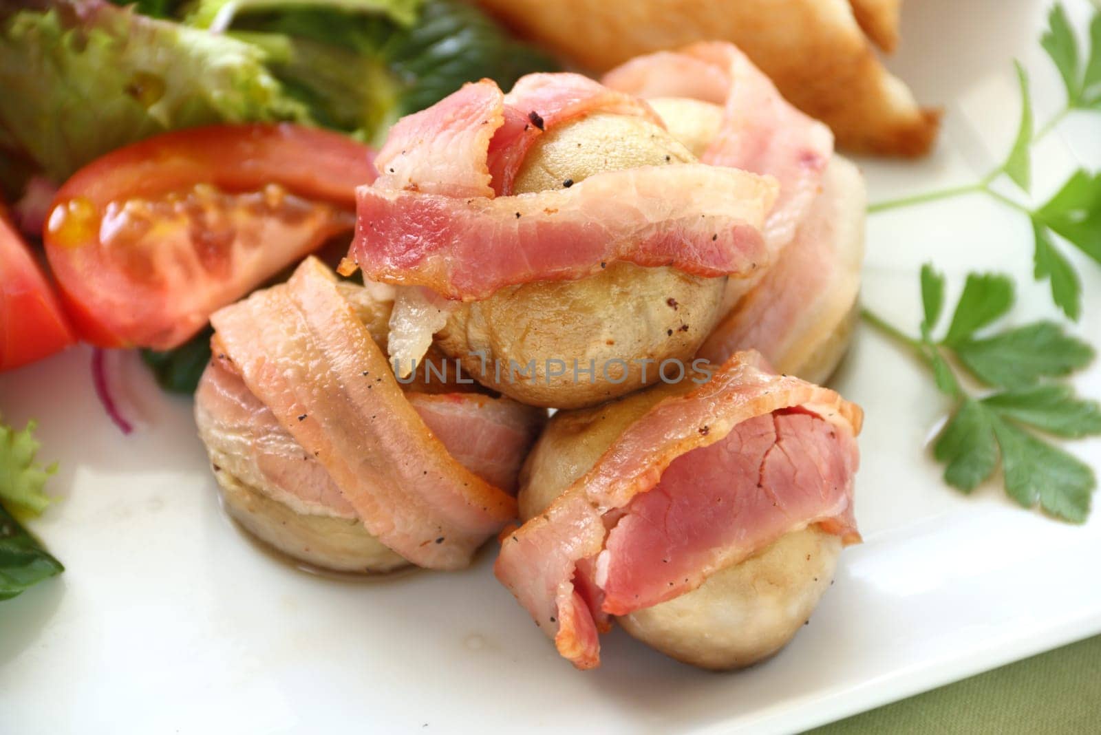 Delicious bacon wrapped mushrooms served with a fresh garden salad.