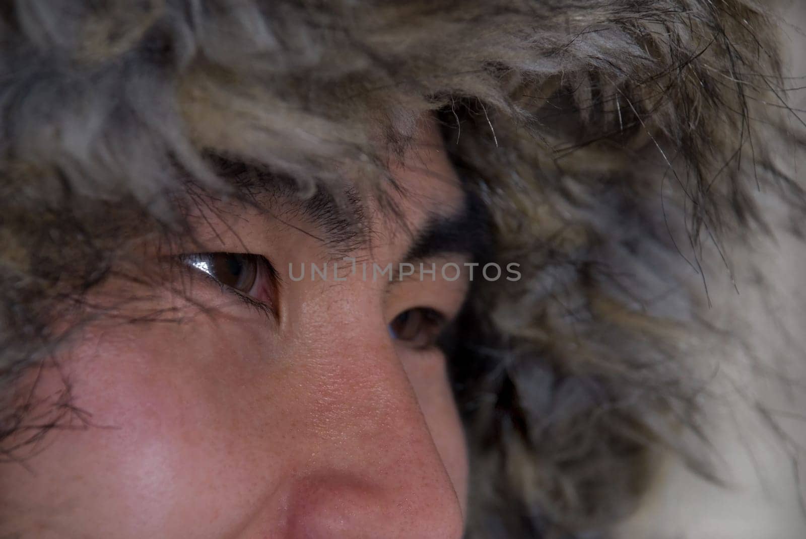 closeup of asian or inuit looking man with coat above his head, in outline