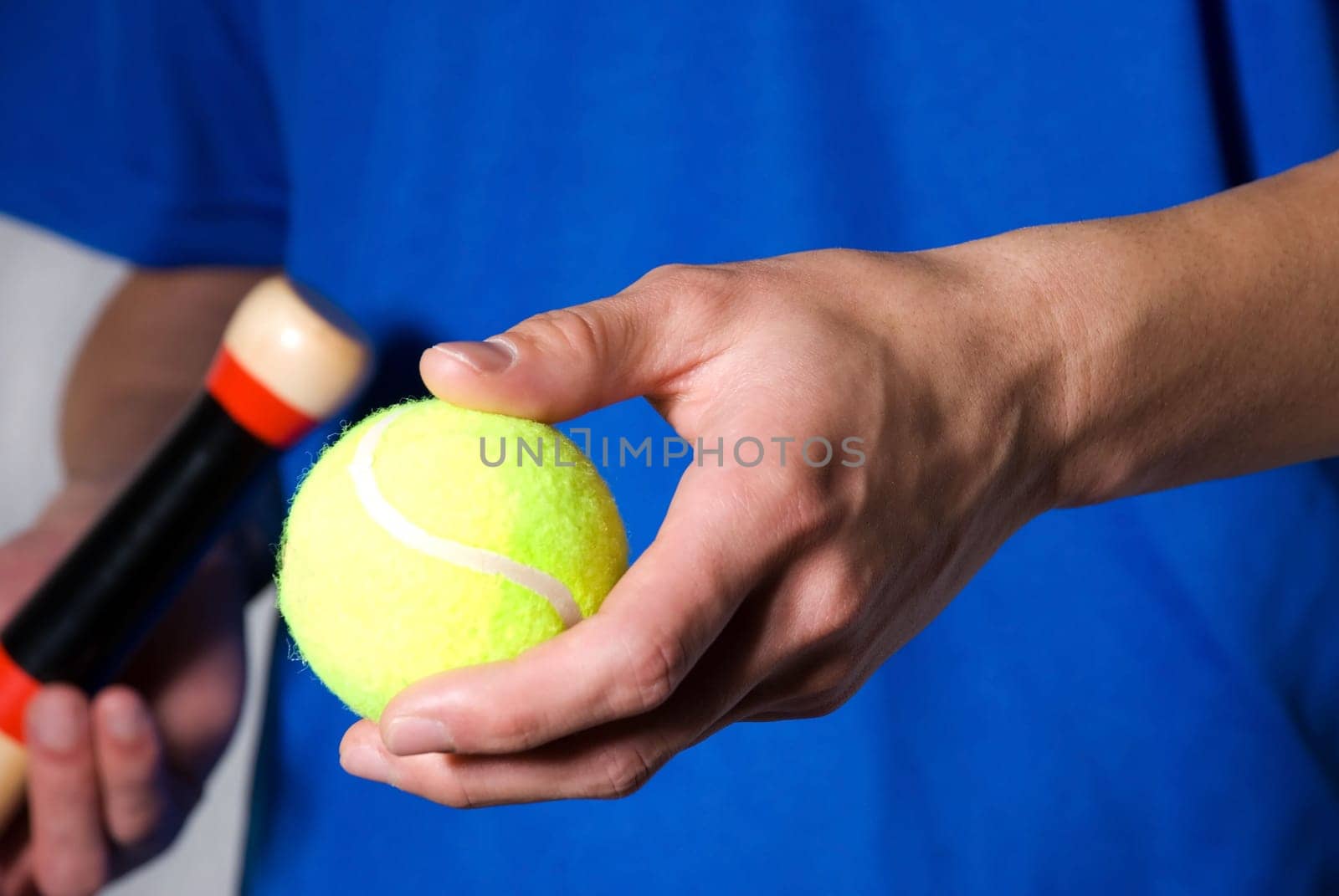 hands holding tennis ball and racket as cutout