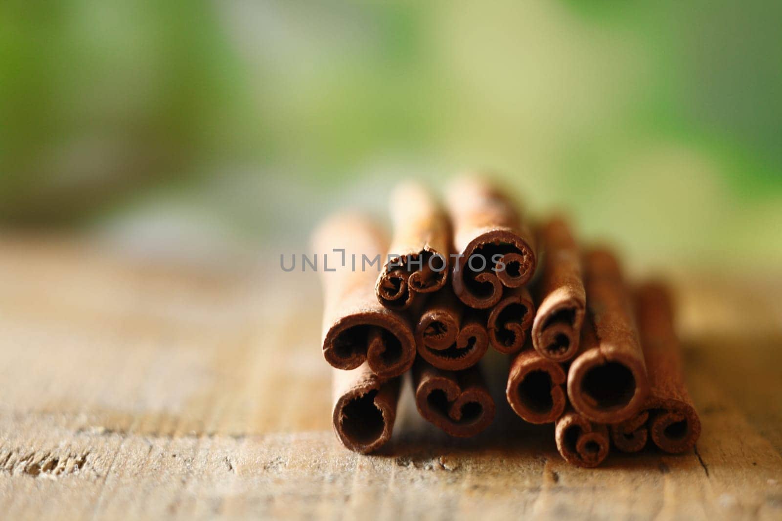 Closeup of a bunch of dried spicy cinammon sticks on a wooden surface with copyspace