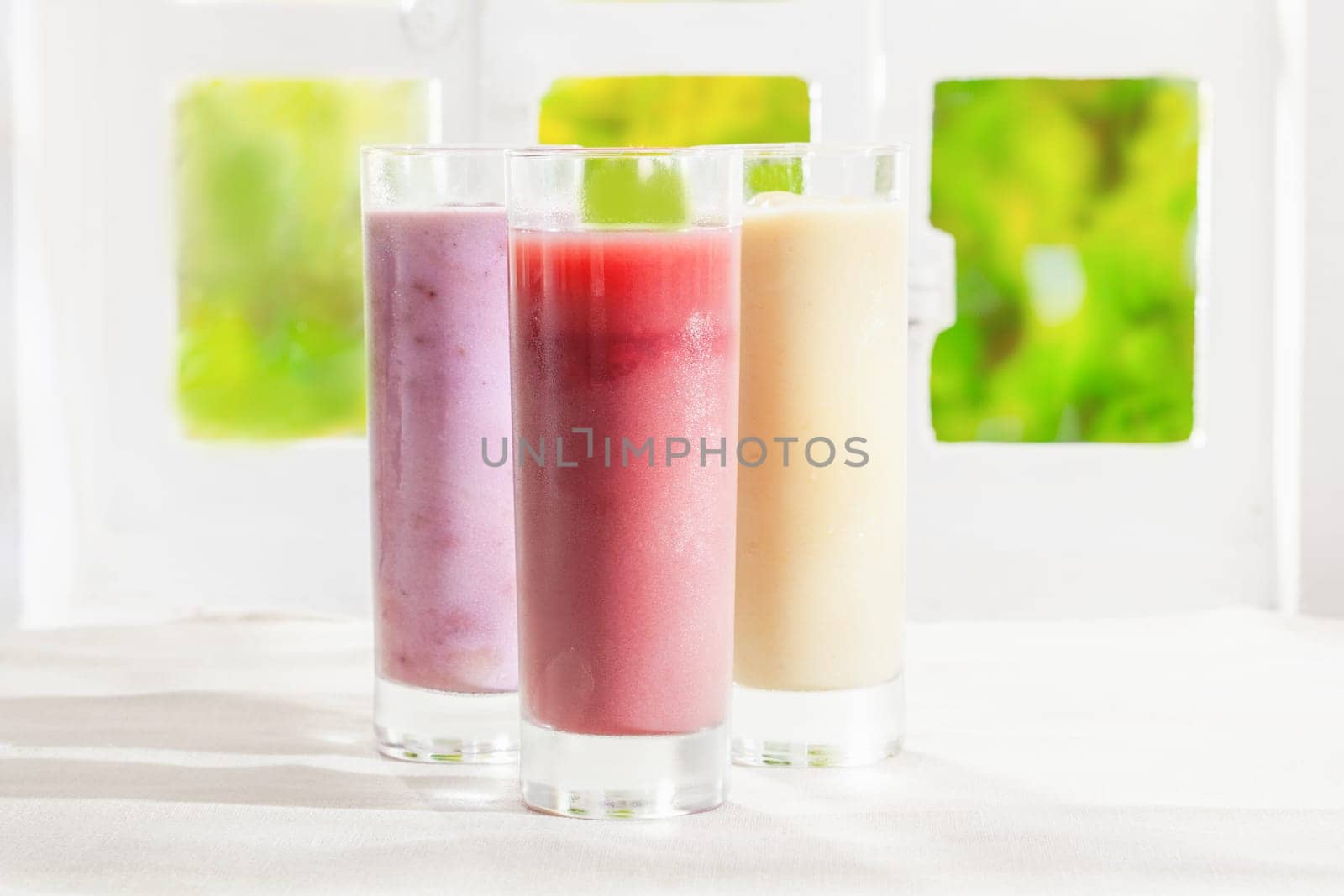 Variety of healthy fresh fruit t smoothies in glasses made from a blend of creamy yoghurt and liquidised fruit