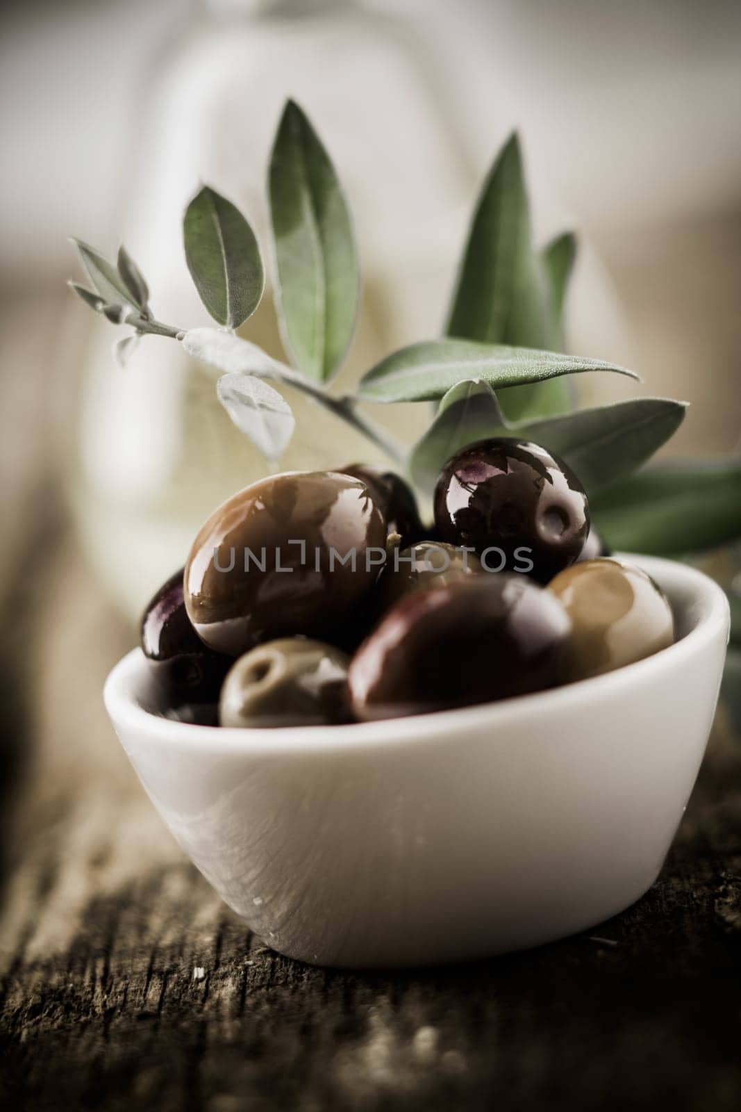 Closeup of a bowl of whole fresh organic black olives with shallow dof
