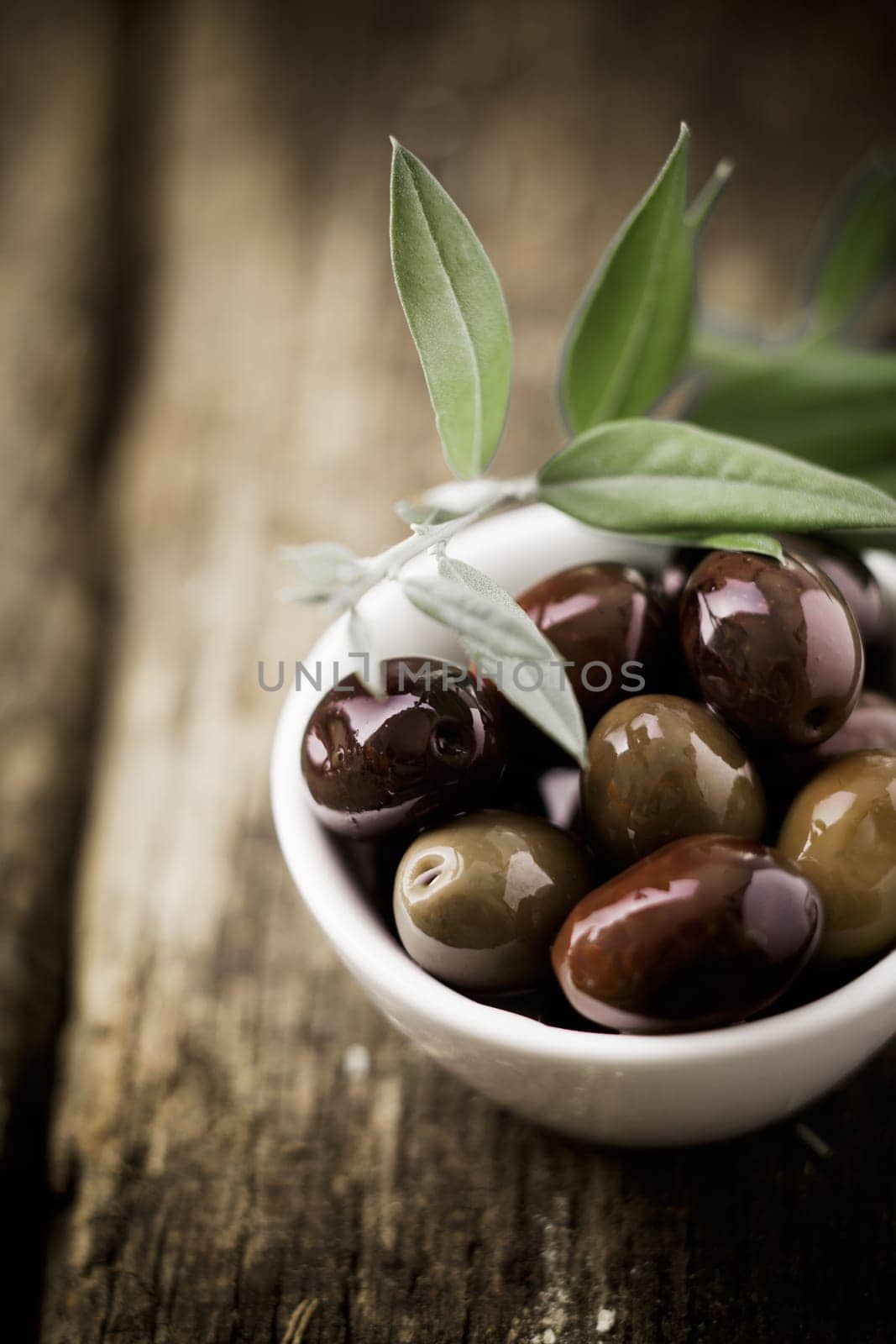 Fresh black olives in a bowl for appetizers to be served with drinks before a meal with copyspace