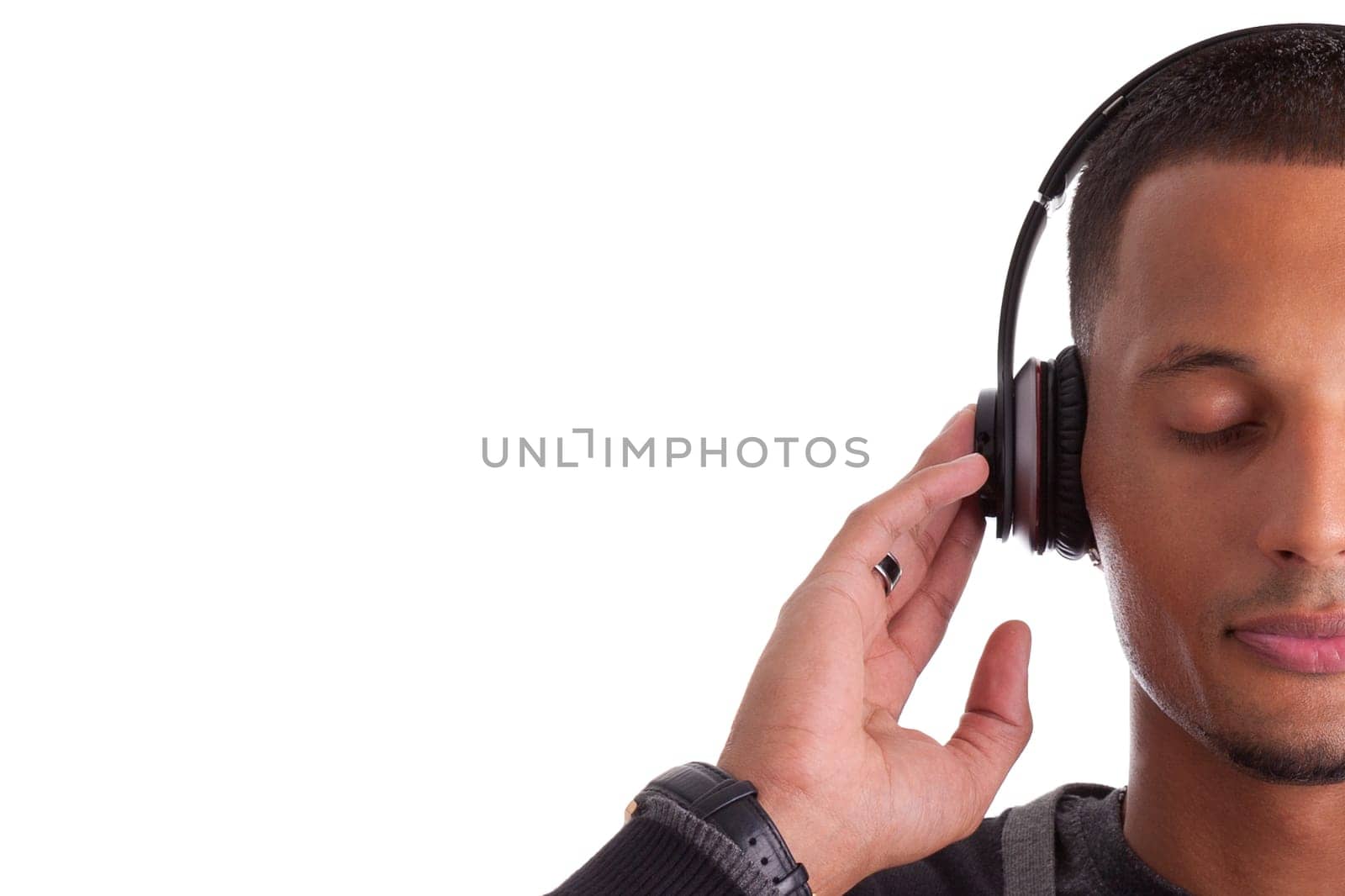 Young black man with closed eyes listening to music, isolated on white background