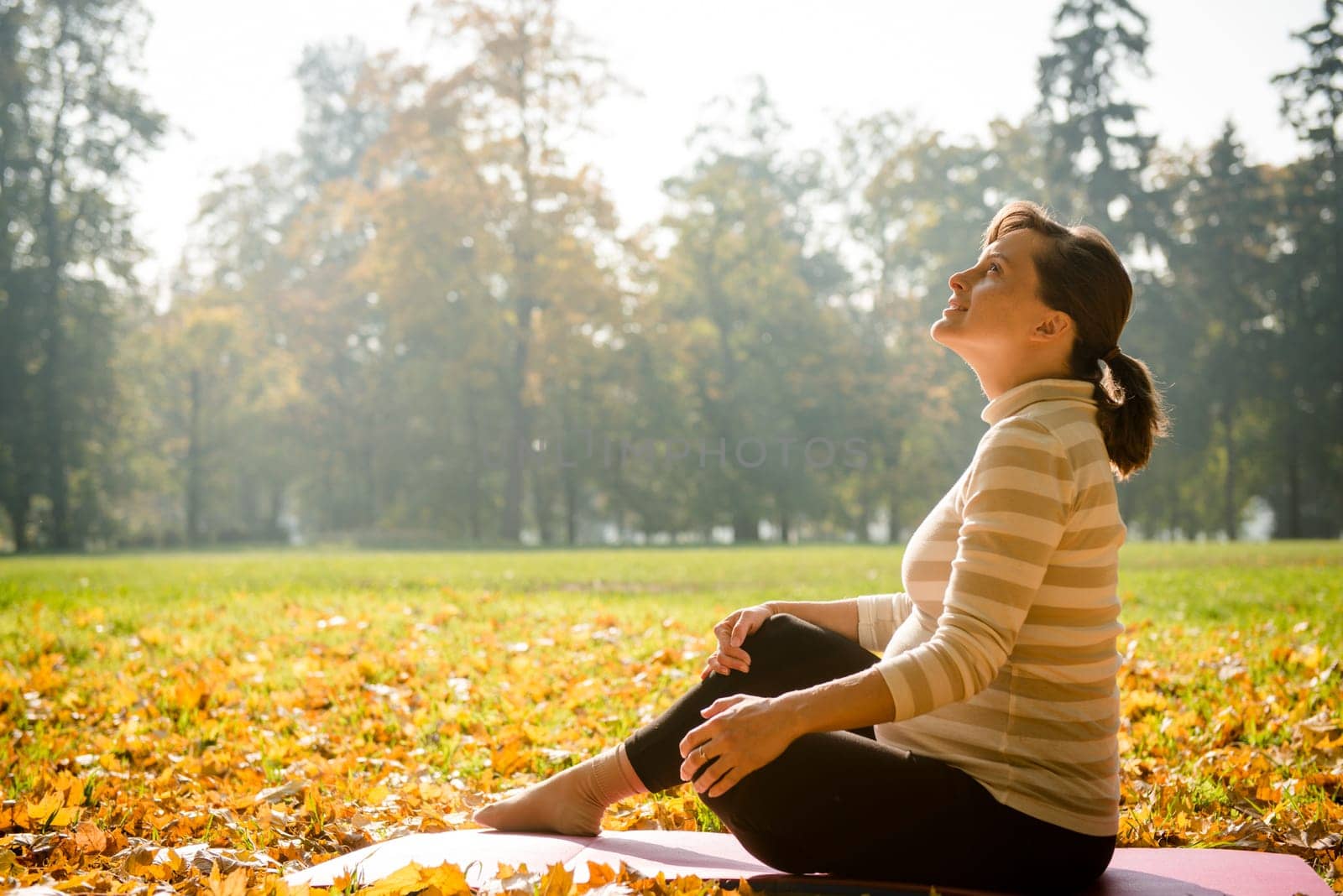 Happy pregnant woman looking to sky in autumn beautiful nature