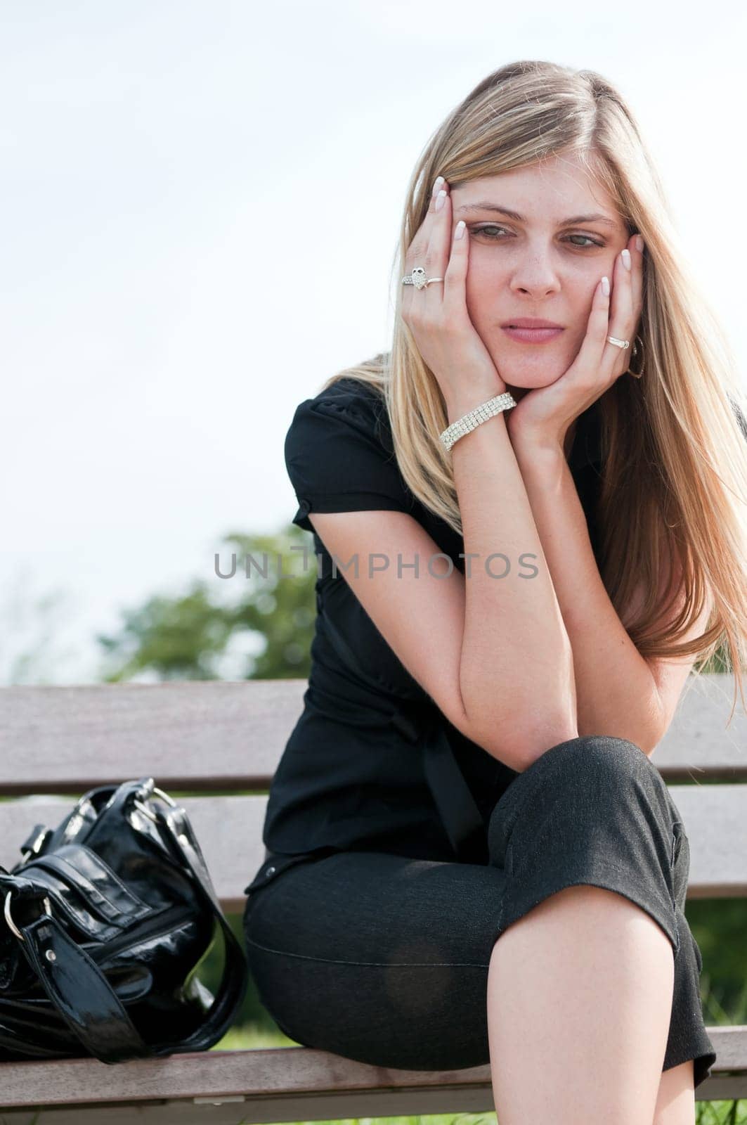 Young worried beautiful woman siting on bench - head in hands