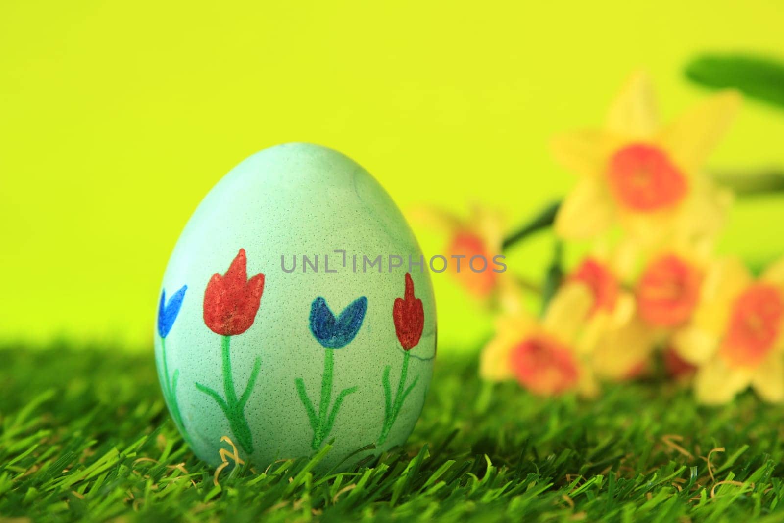 Easter decoration made of single,colorfully painted,Easter egg in green artificial grass