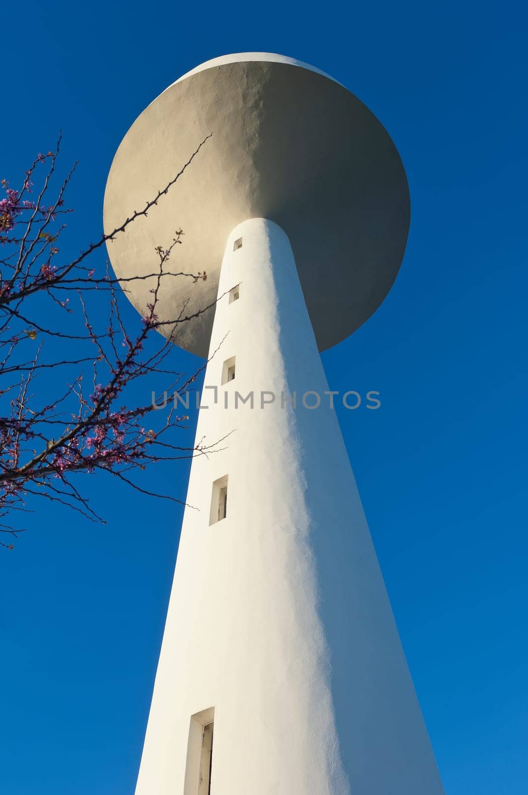 White painted water tower against a clear blue sky in the small village of S. Bartolomeu do Outeiro,  Alentejo, Portugal
