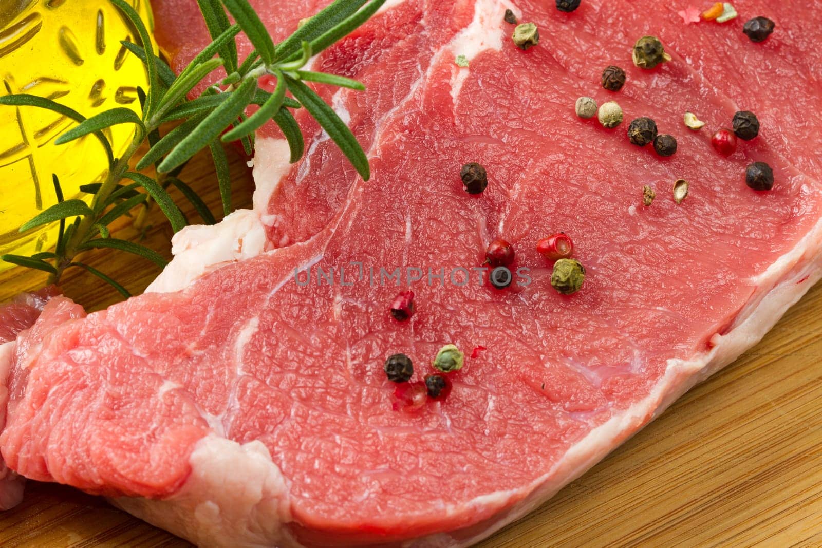 raw T-bone with rosemary and pepper