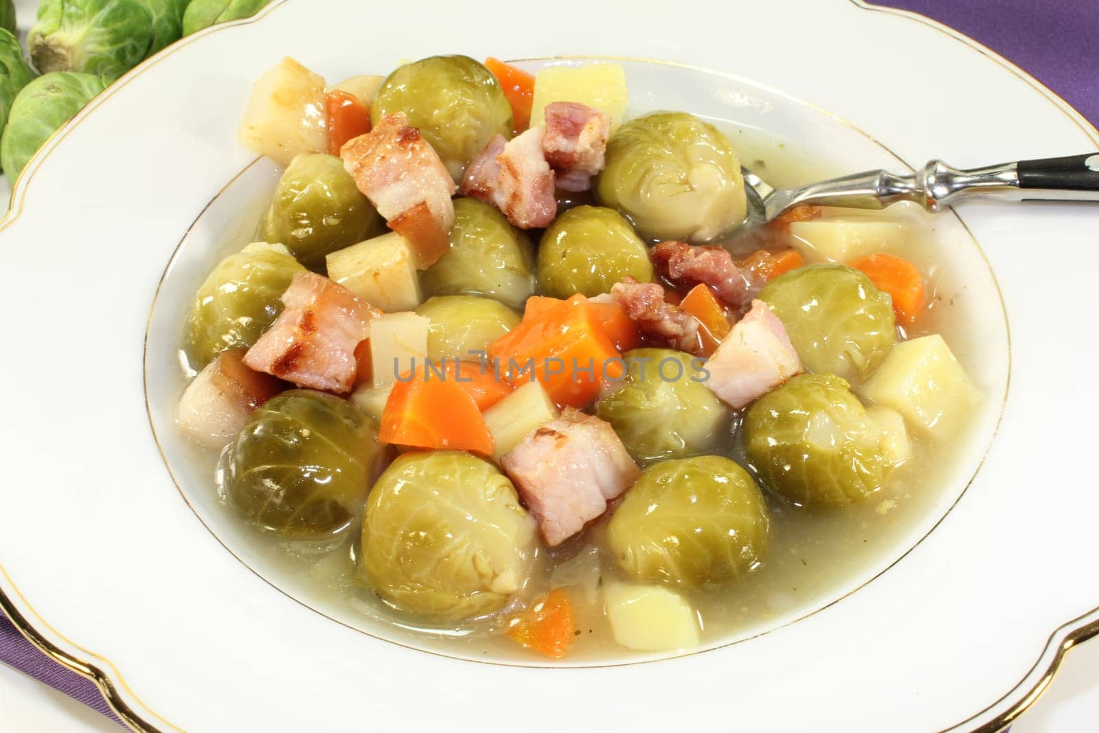 a plate of Brussels sprout stew with colorful vegetables and bacon