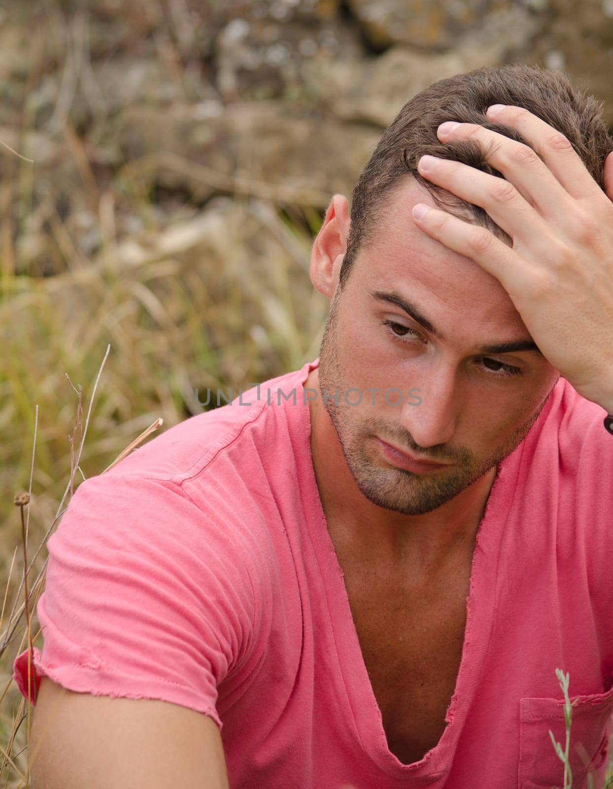 Sad or thoughtful good looking male model with pink shirt