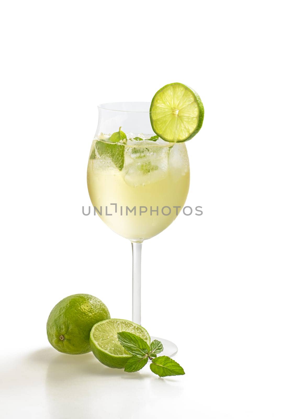 Aperitif with limes and mint in a wine glass