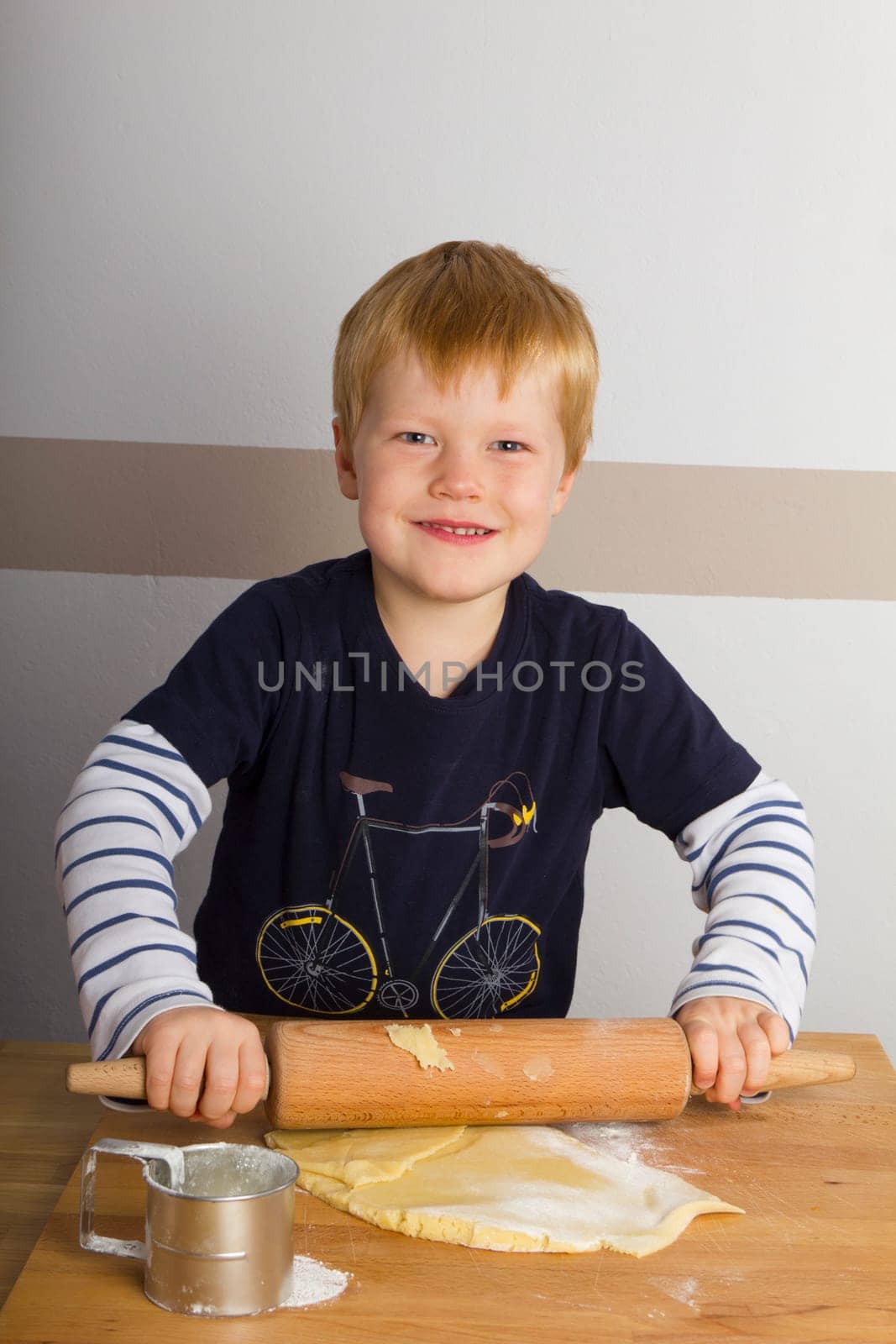 Child rolls out dough with a rolling pin