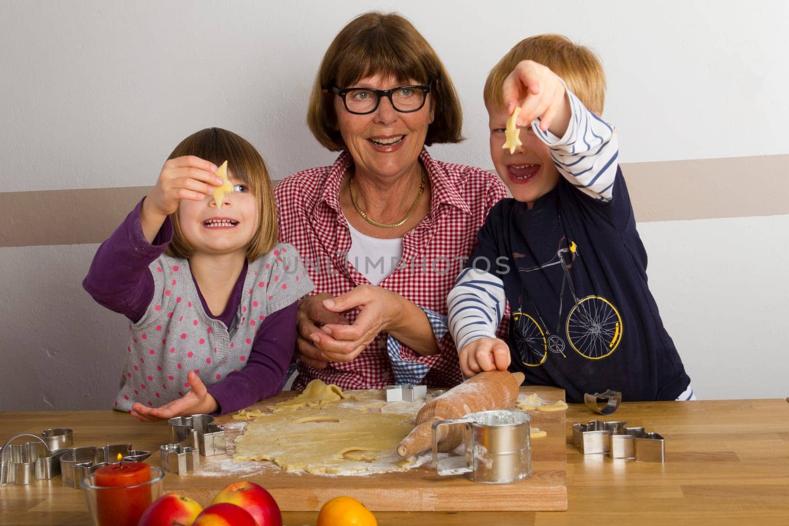 Grandma and grandchildren cut out cookies
