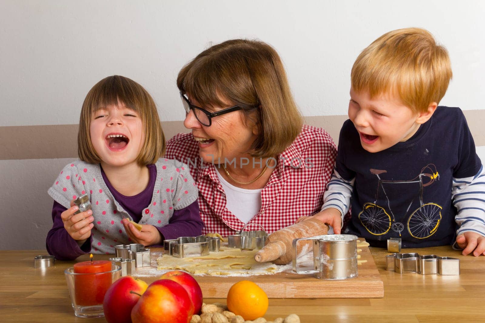 Grandma and grandchildren cut out cookies