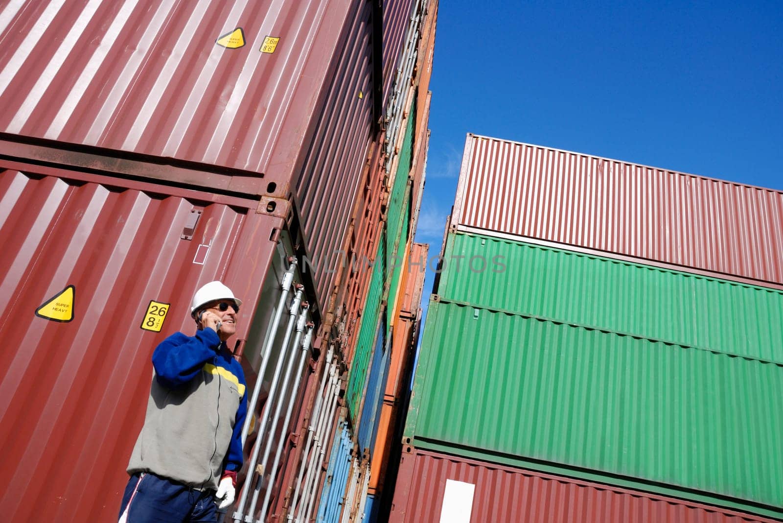 port and dock worker with stacks of containers in background