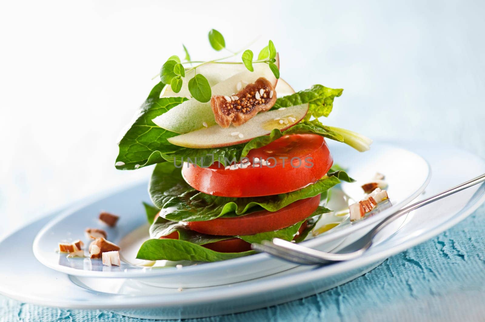 Fresh green salad with tomato, fig and origano close up