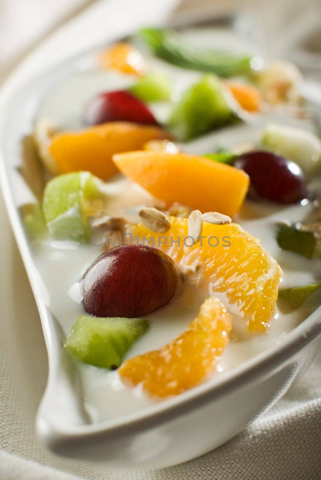 mixed fruit in yogurt with muesli flakes close up