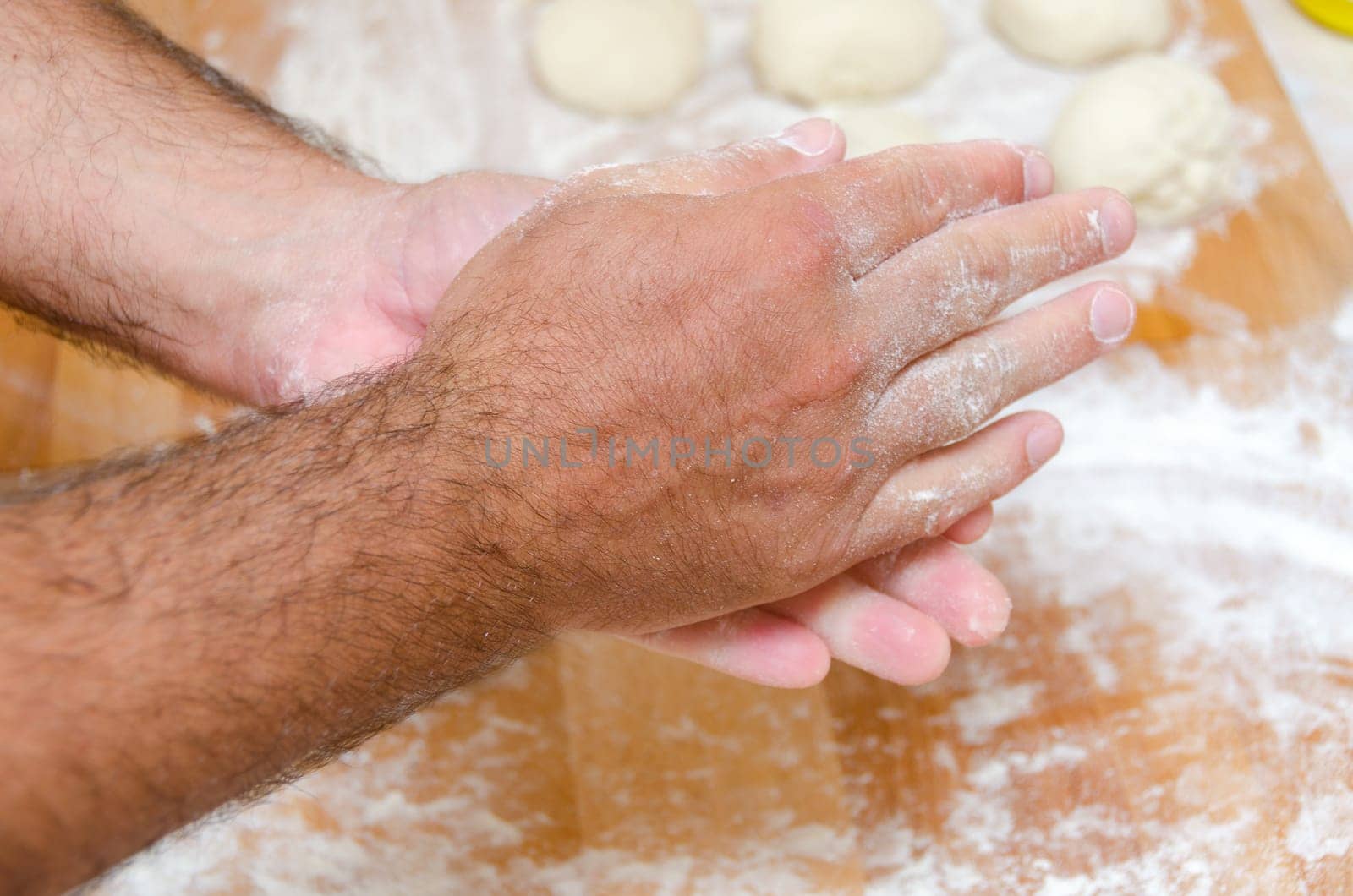 hands of the cook while preparing the pizza dough