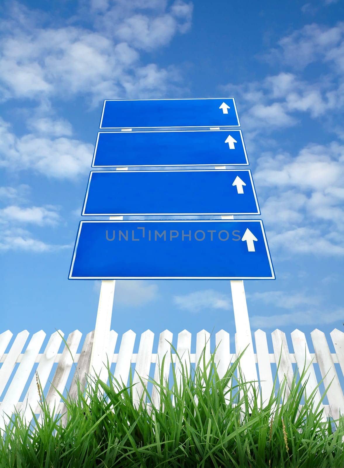 signpost with white fence and blue sky