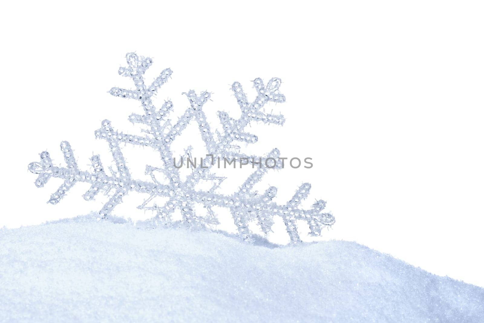 ICE CRYSTAL IN THE SNOW AGAINST WHITE BACKGROUND