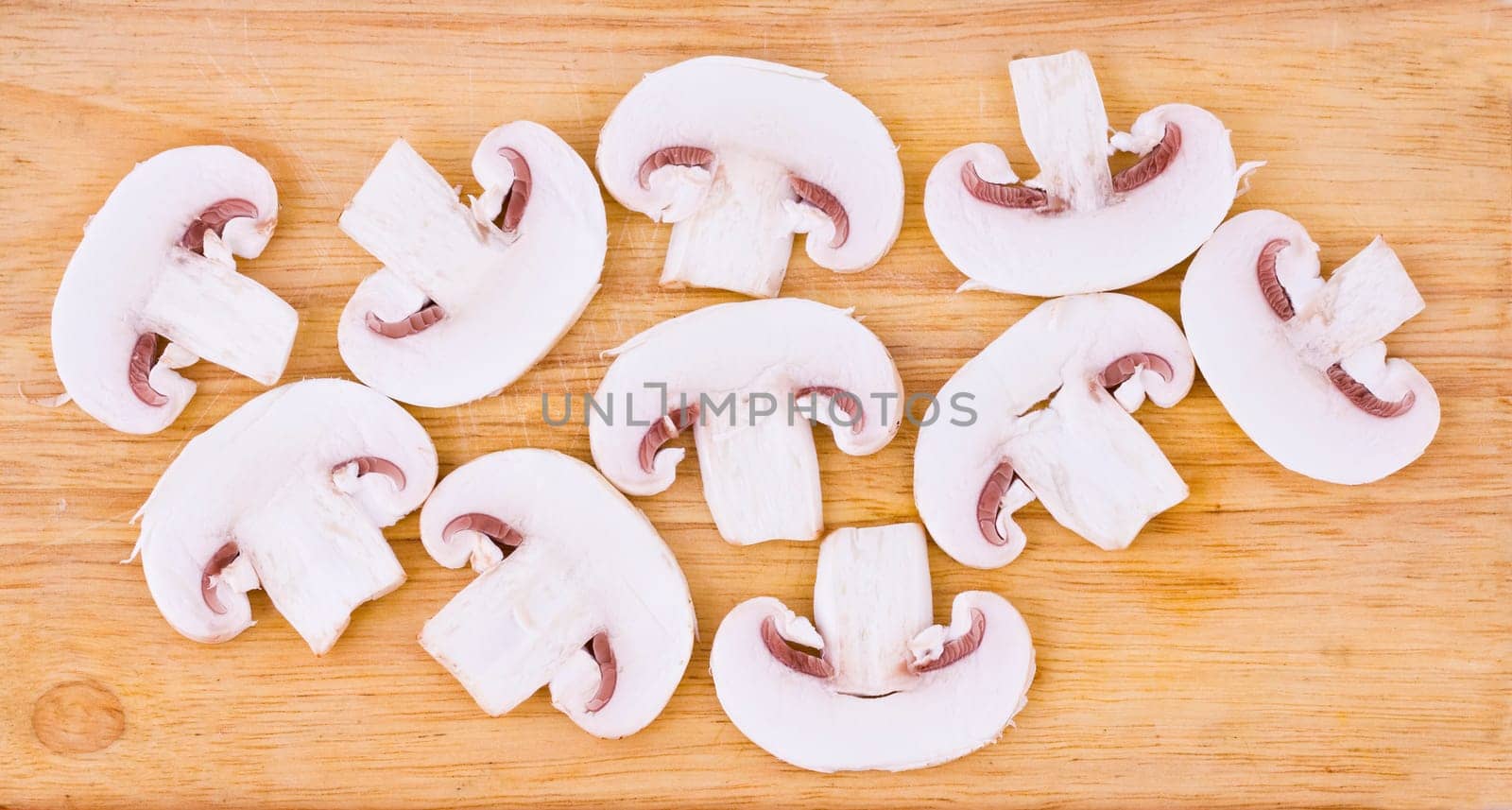 Sliced mushrooms on the wooden cutting board background