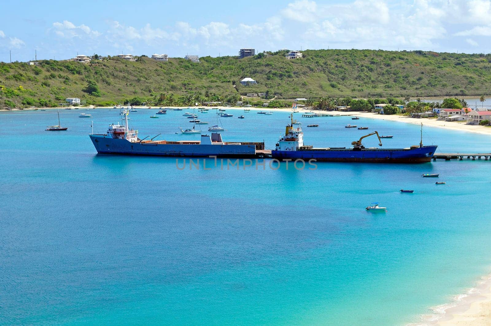 Two ships offloading cargo at caribbean port.