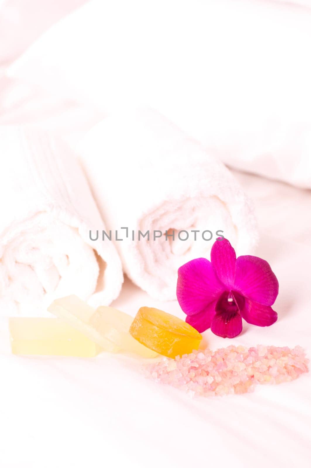Spa concept orchids, bath soap and bath salt on a bed in a hotel room
