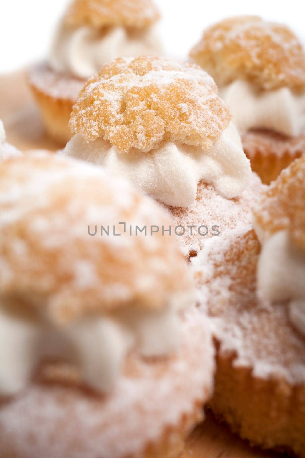 A group of fresh cakes with cream on wooden board