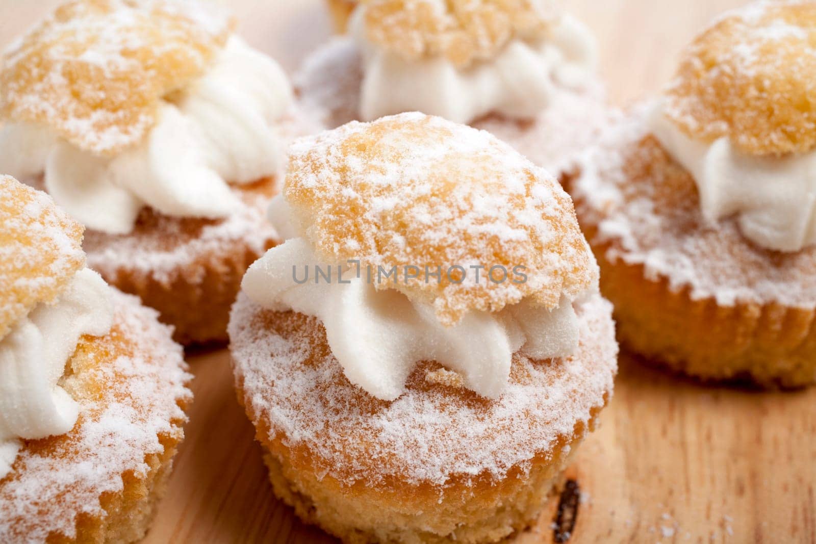 A group of fresh cakes with cream on wooden board