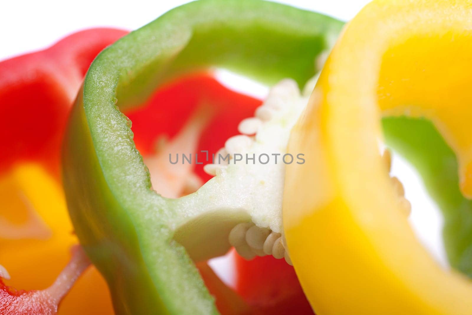 Red Yellow and Green peppers sliced on an isolated white background