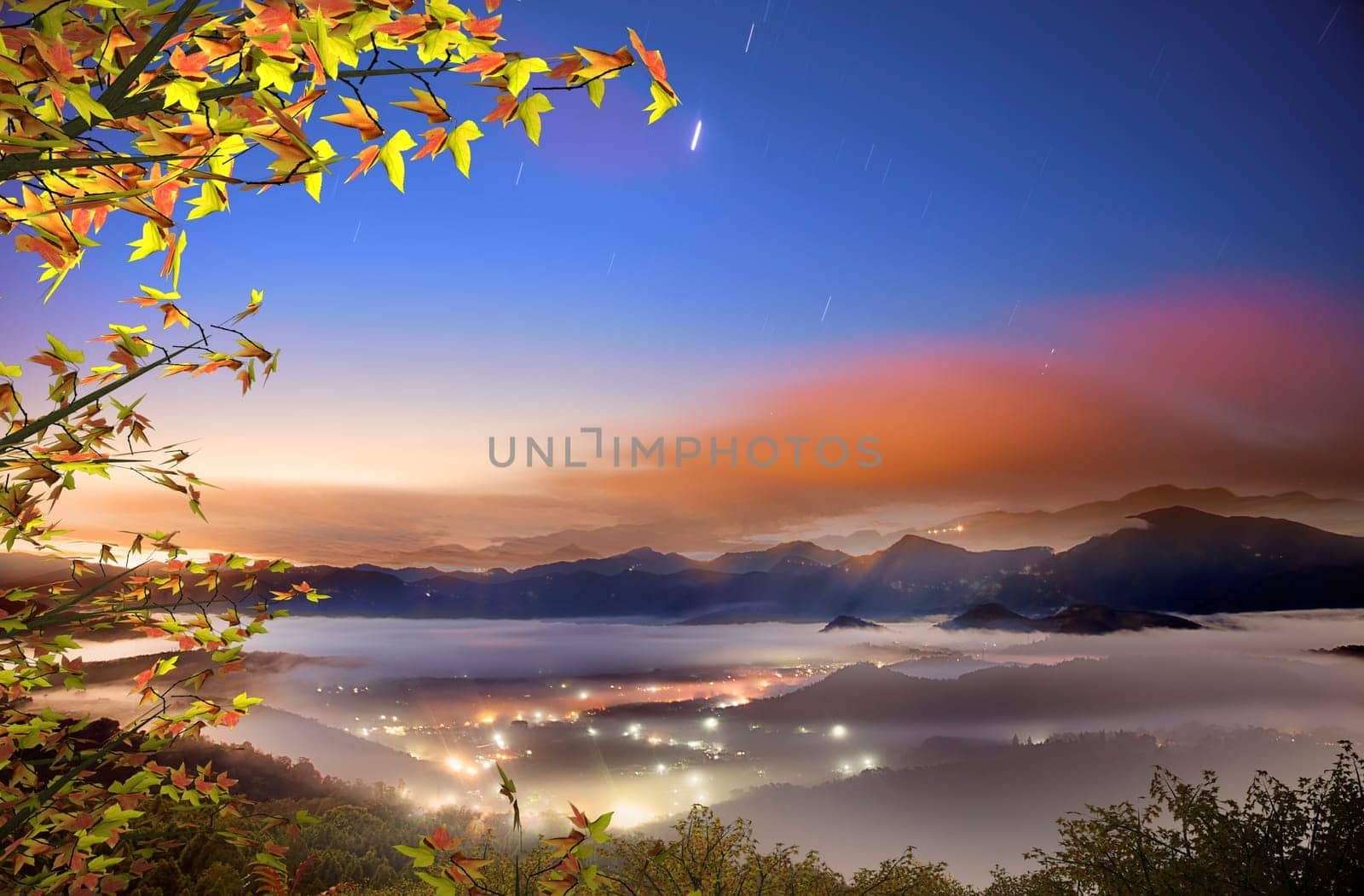 The sun setting over mountains with nice maple
