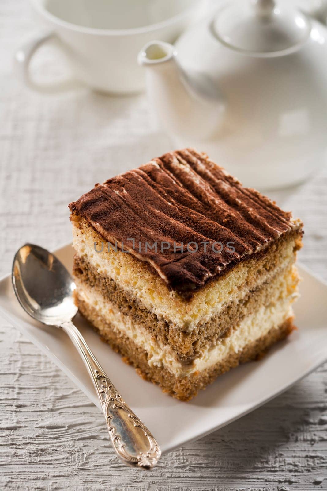 Tiramisu cake on white plate close up shoot