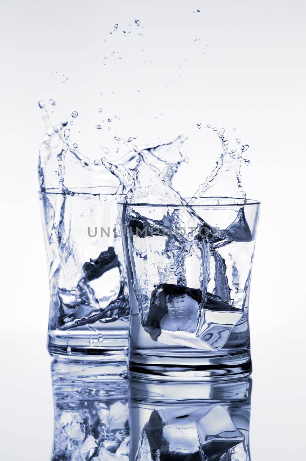 ice cube splashing in to glass close up