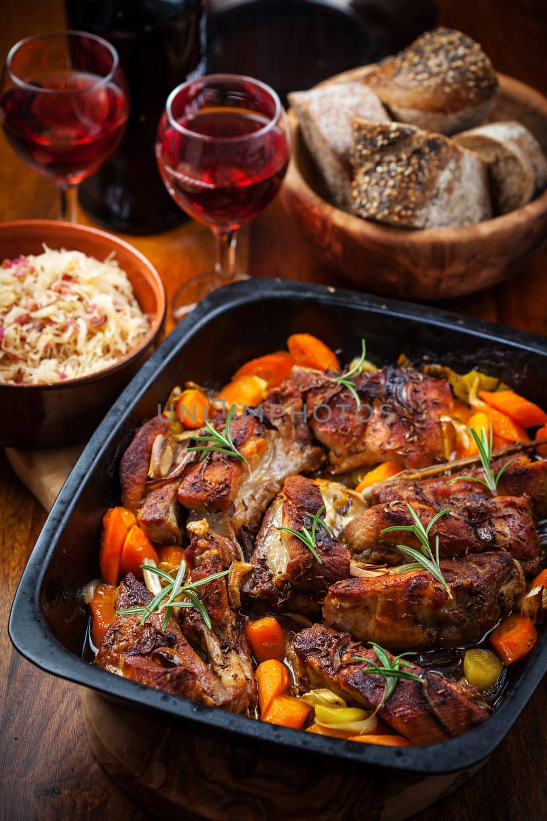 Roasted pork belly on vegetables with sauerkraut and red wine
