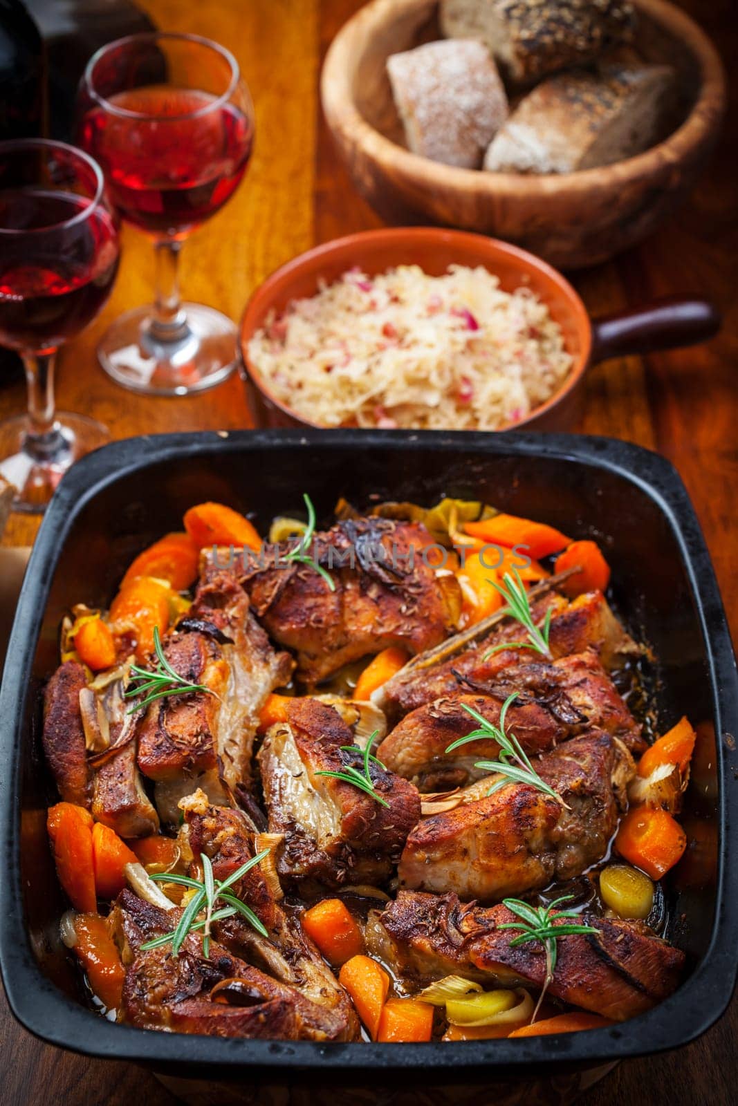 Roasted pork belly on vegetables with sauerkraut and red wine