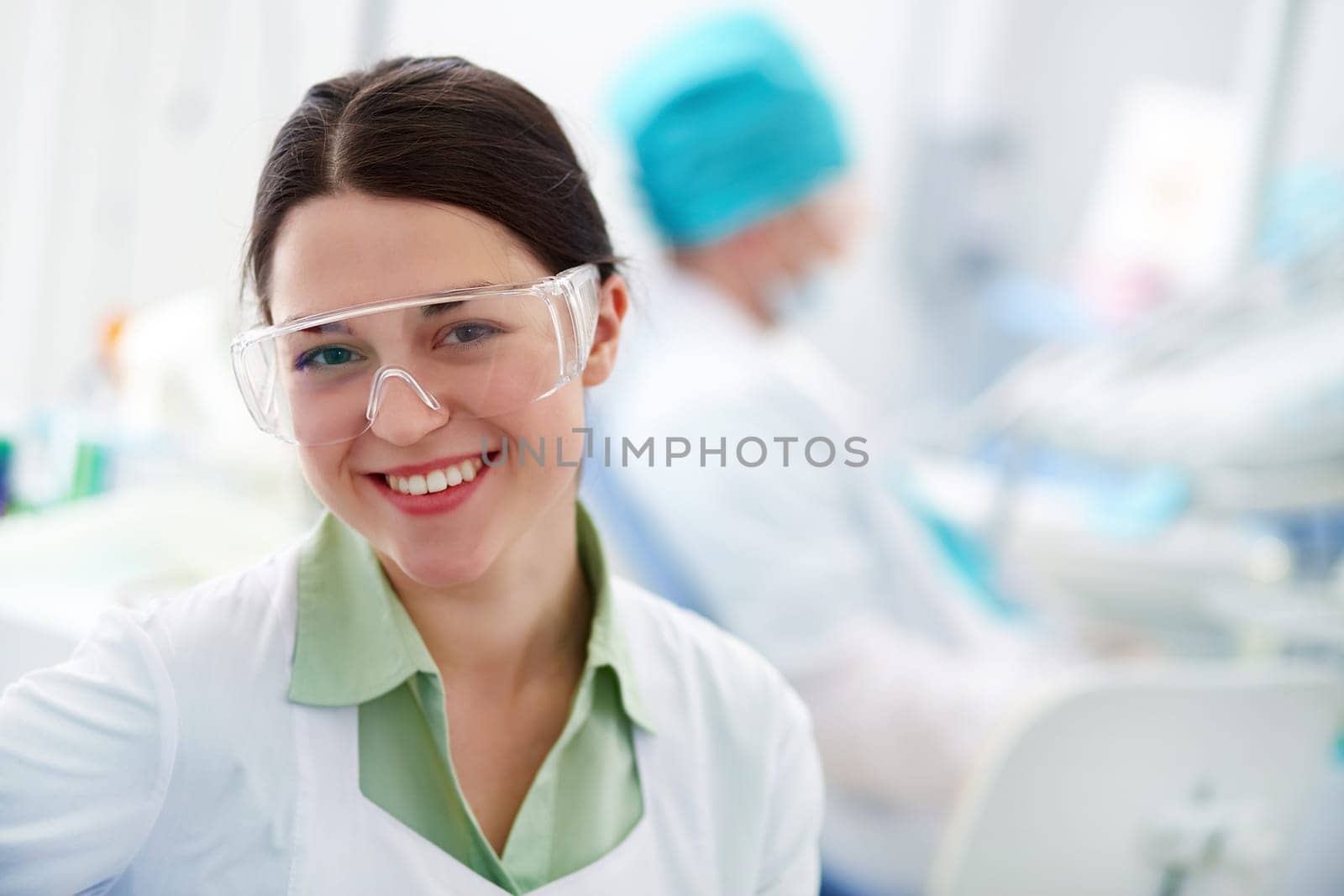 Pretty assistant in protective eyewear looking at camera