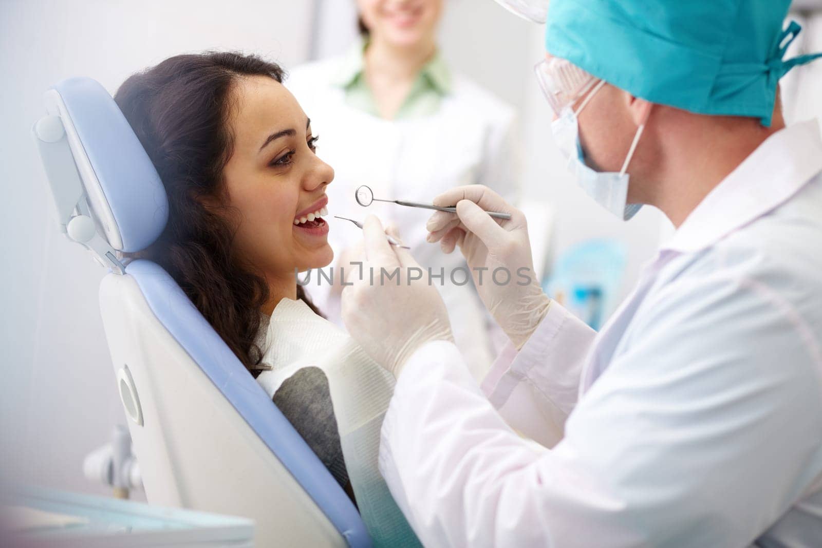 Pretty girl sitting at the dentists and having mouth checkup