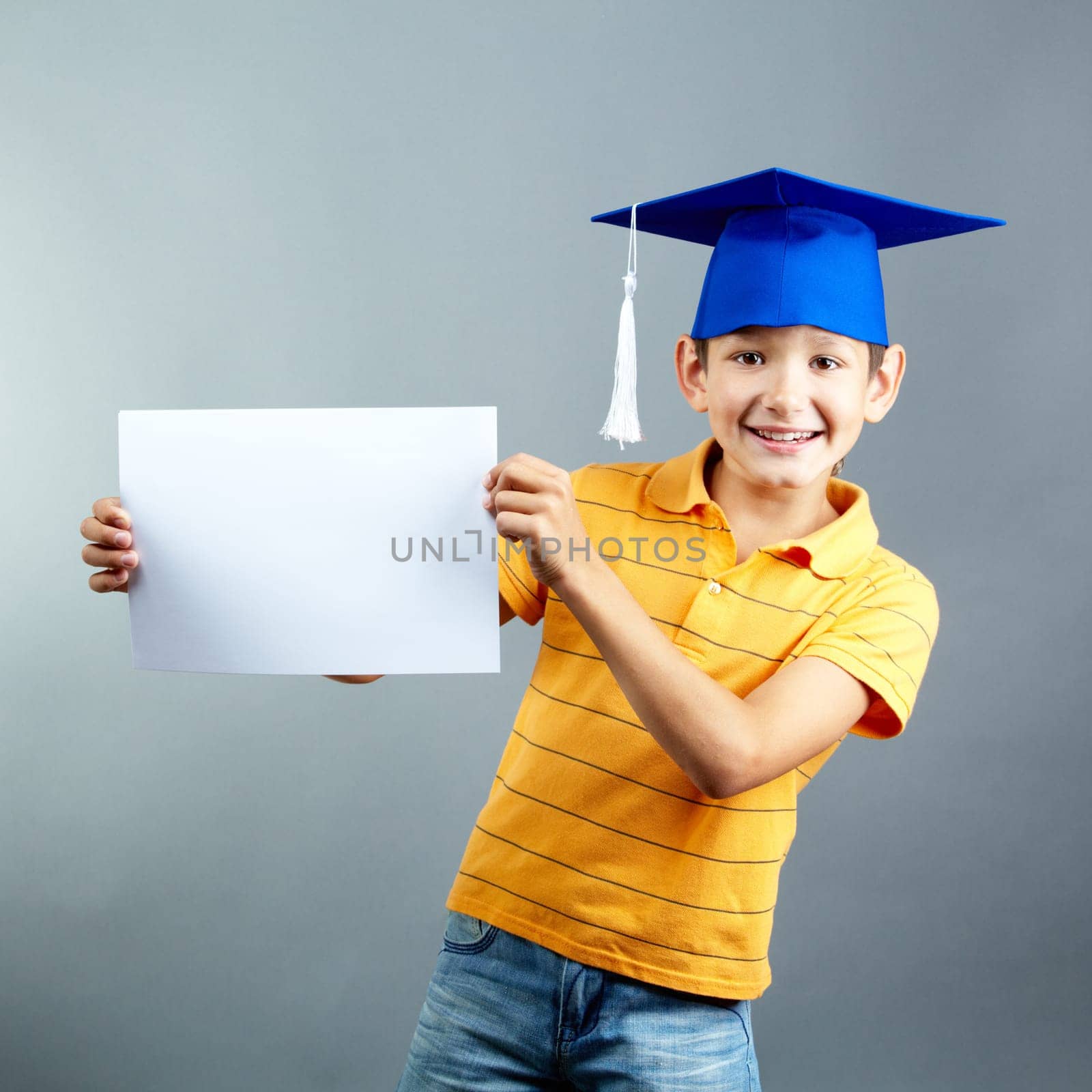 Portrait of happy boy with blank paper looking at camera