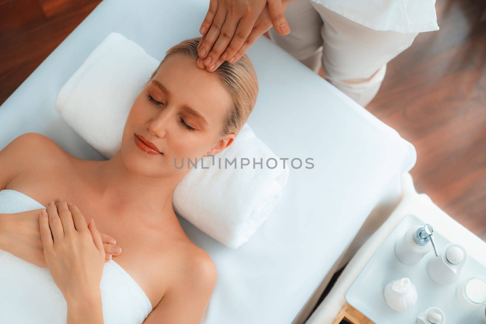 Panorama top view of woman enjoying relaxing anti-stress head massage and pampering facial beauty skin recreation leisure in dayspa modern light ambient at luxury resort or hotel spa salon. Quiescent