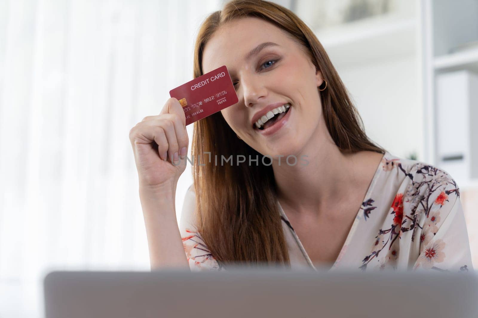 Young happy woman buy product by online shopping at home while ordering items from the internet with credit card online payment system protected by utmost cyber security from online store platform