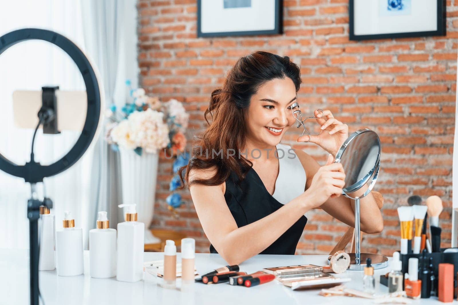 Woman influencer shoot live streaming vlog video review makeup uttermost social media or blog. Happy young girl with cosmetics studio lighting for marketing recording session broadcasting online.