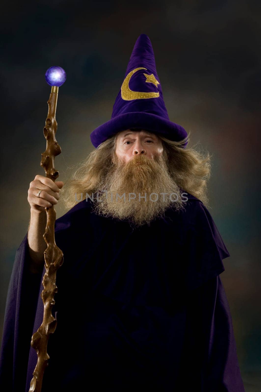 Image of a man dressed as a wizard holding a glowing staff.