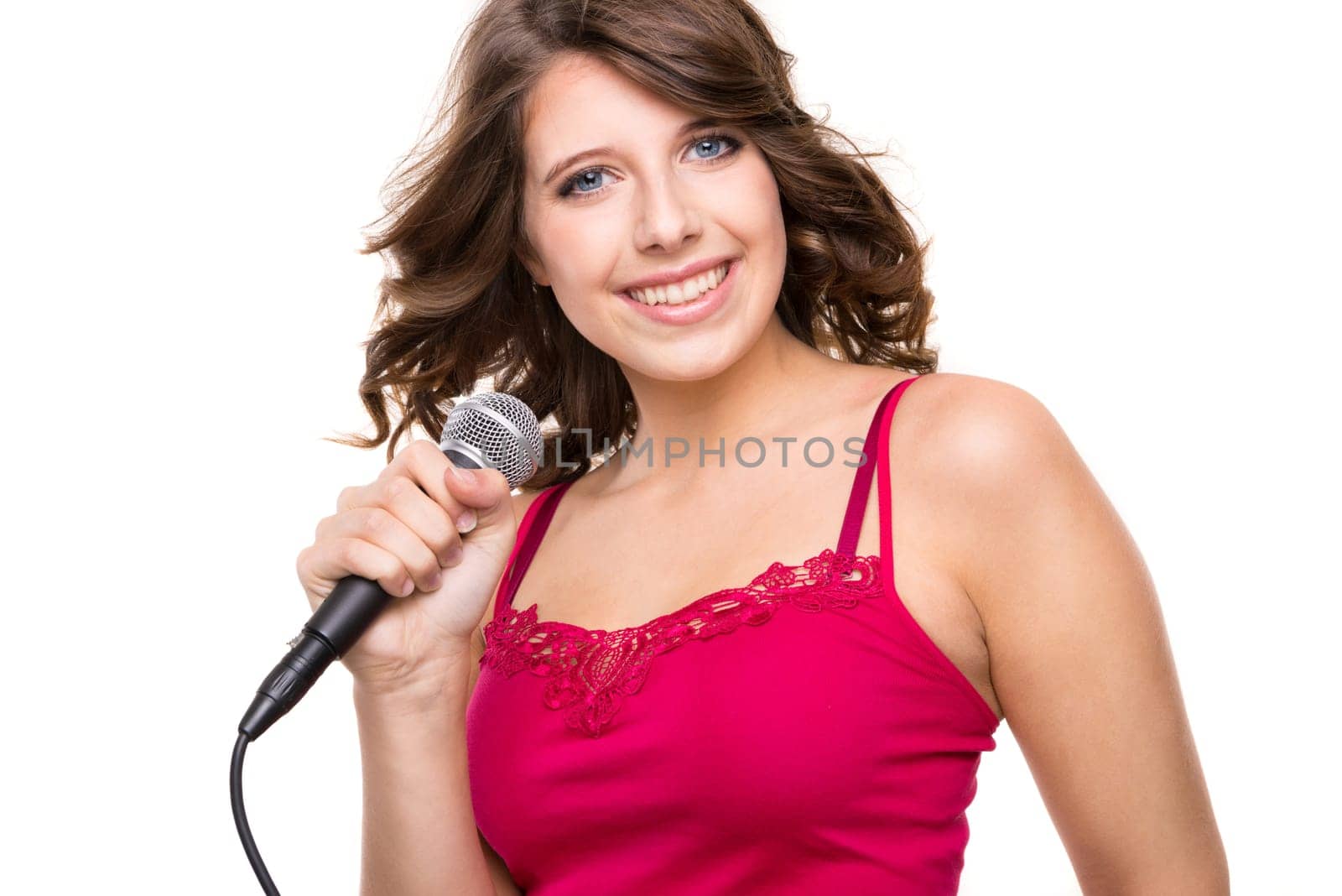 Young and smiling girl with microphone against white background