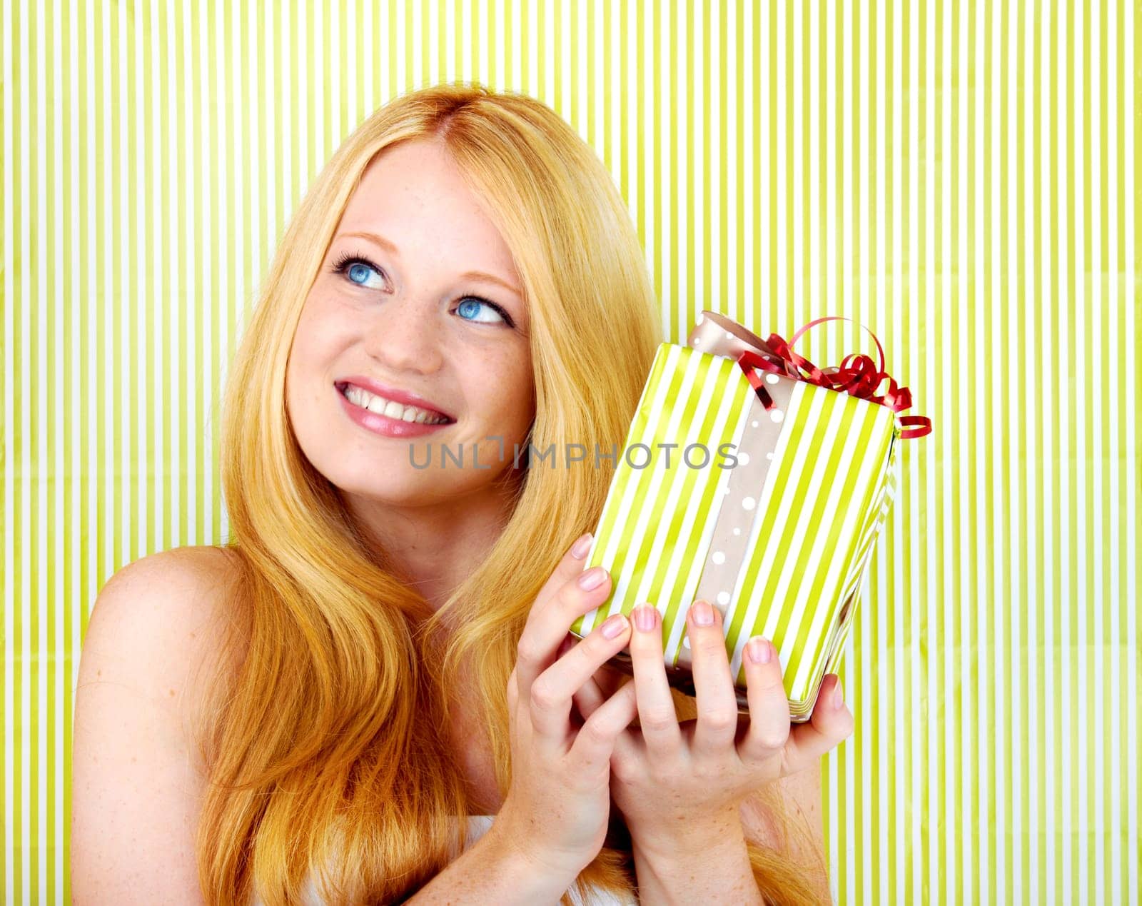 beautiful blonde woman holding a christmas gift is smiling