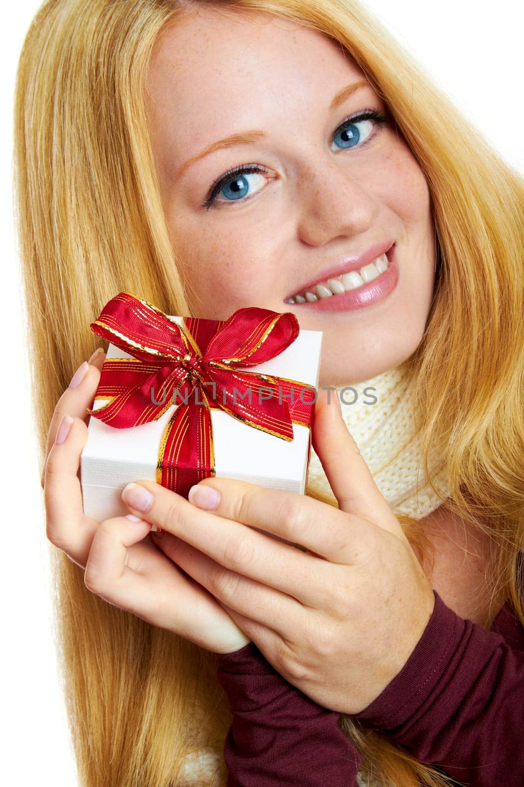 beautiful blonde woman holding a christmas gift is smiling
